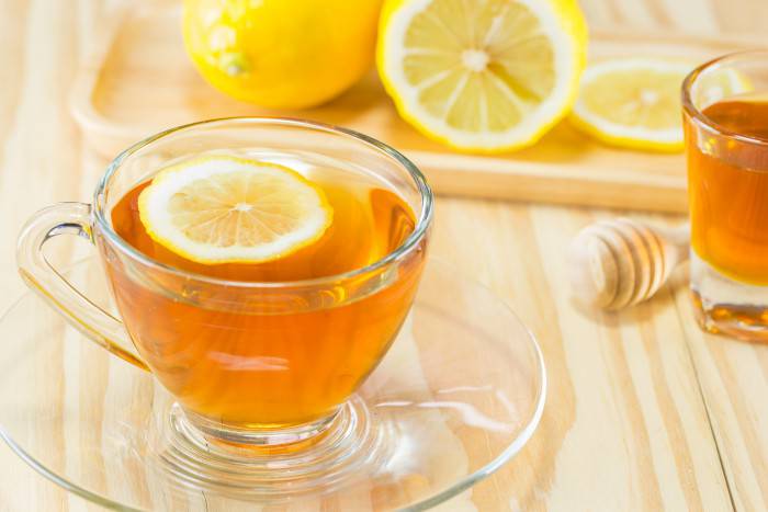 tea with honey and lemon on wood background,warm toning