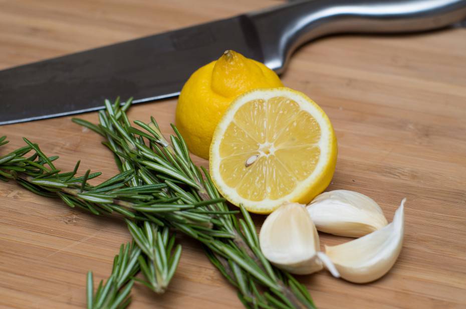 Garlic, Rosemary, Lemon and Knife on Cutting Board
