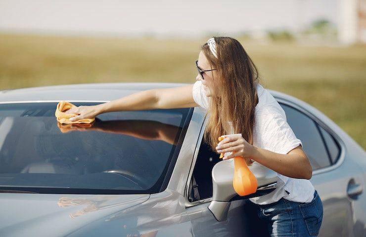 pulizia del parabrezza dell'auto con l'olio evo