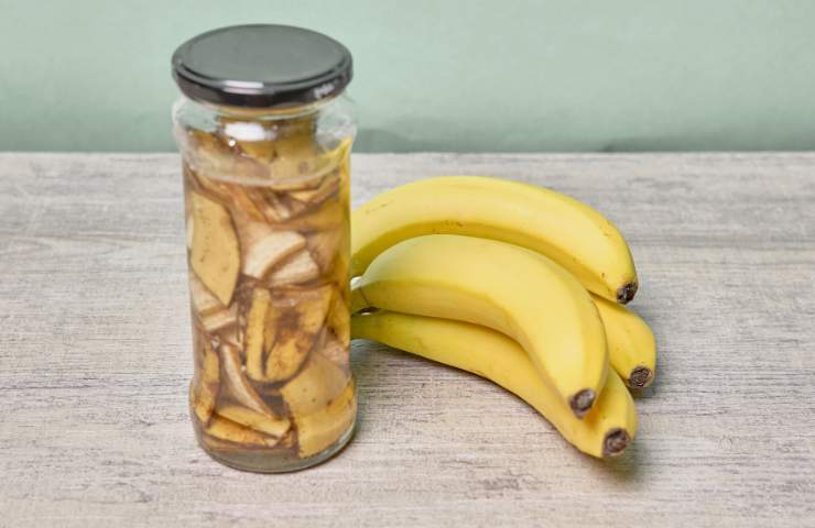 Delle banane e delle bucce in un barattolo con aceto