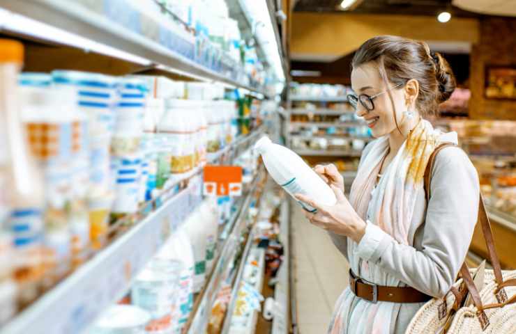 Una donna fa la spesa comprando del latte
