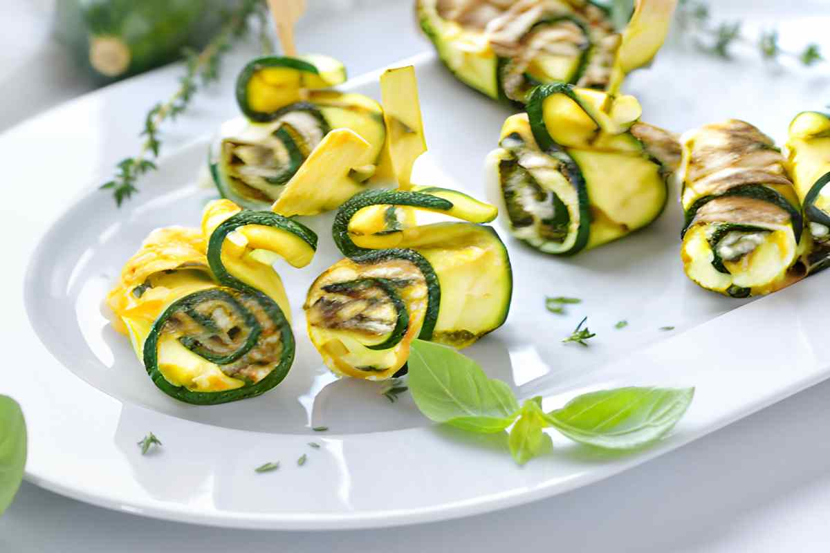 Spiedini di zucchine con prosciutto crudo e scamorza affumicata in un piatto