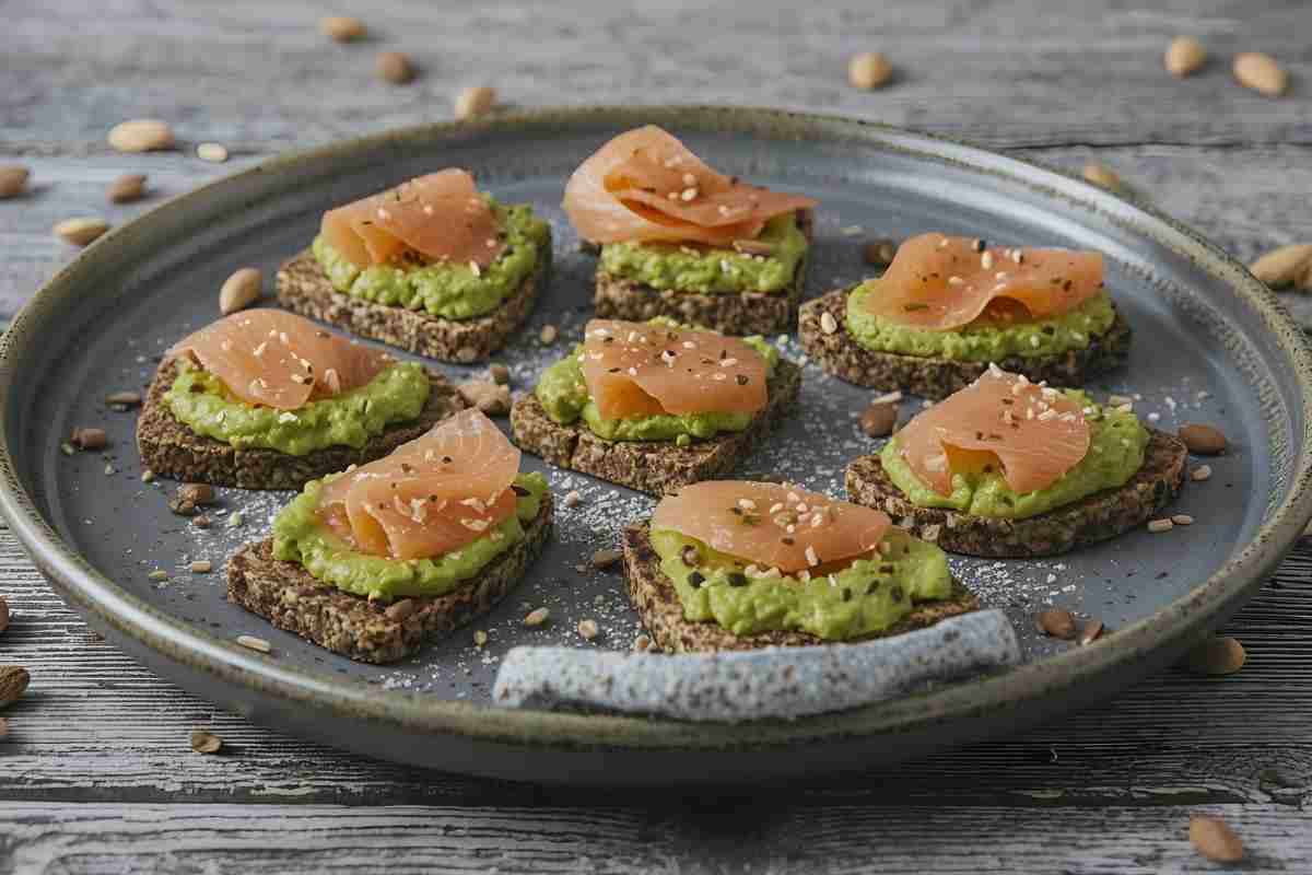 tartine di grano saraceno con crema di avocado e salmone disposte su un piatto